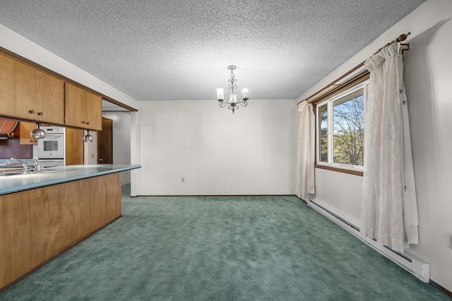kitchen featuring baseboard heating, a textured ceiling, brown cabinetry, an inviting chandelier, and carpet floors