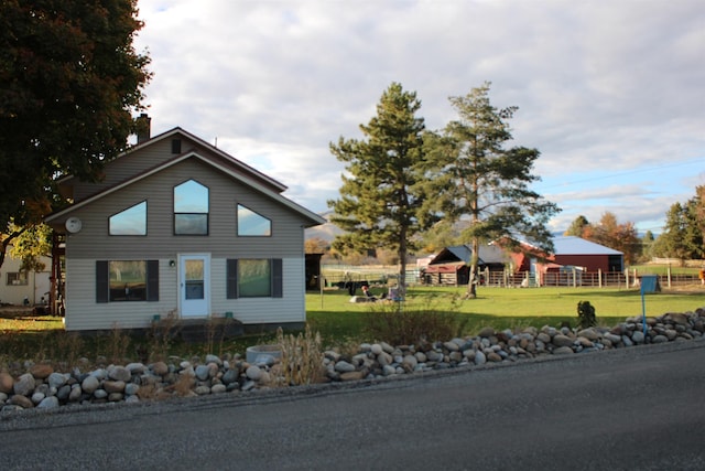 view of front of house with a front yard and fence