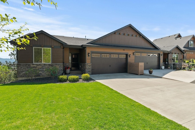 craftsman house featuring concrete driveway, a front yard, an attached garage, and stone siding