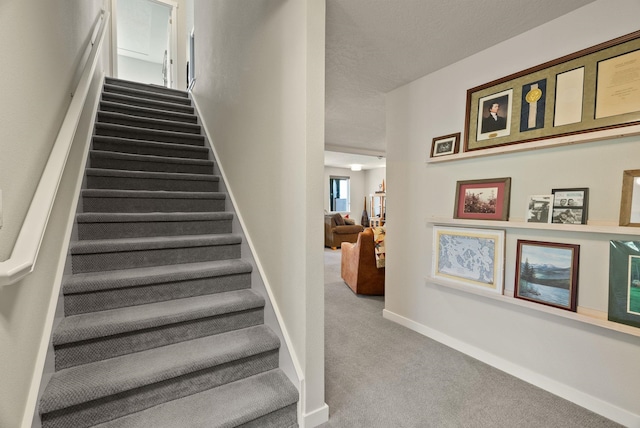 stairs featuring carpet flooring and baseboards