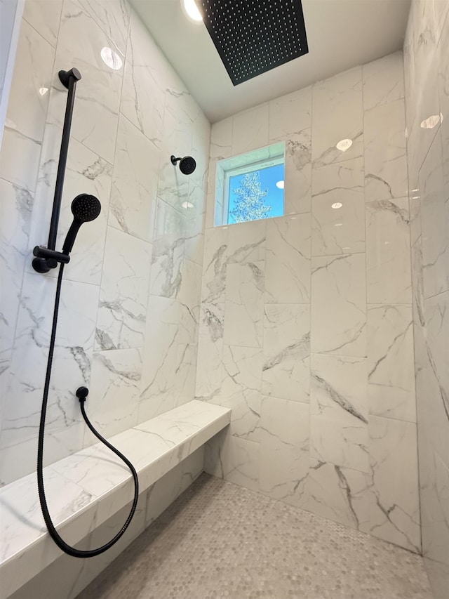 bathroom featuring a marble finish shower