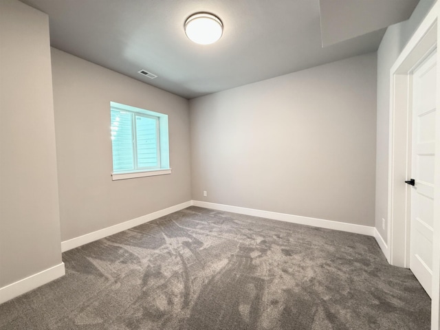 carpeted spare room featuring visible vents and baseboards