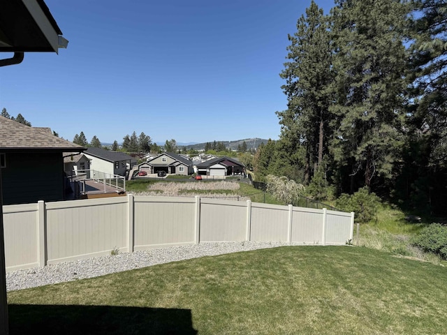 view of yard featuring fence, a mountain view, and a residential view