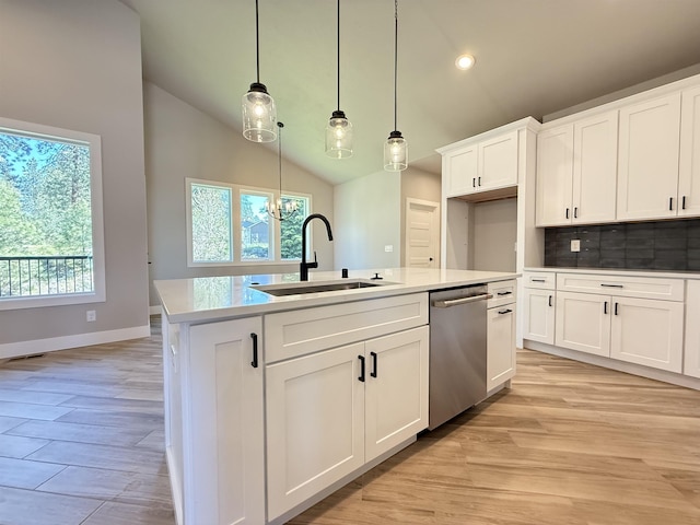 kitchen with vaulted ceiling, stainless steel dishwasher, a healthy amount of sunlight, and a sink