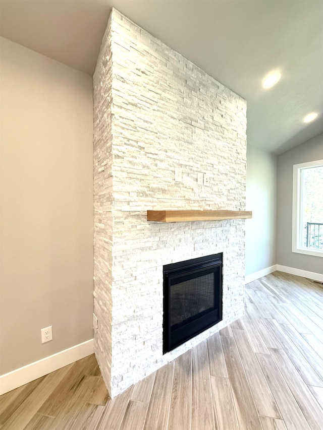 interior details featuring baseboards, a fireplace, and wood finished floors
