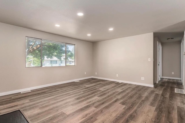 empty room with baseboards, recessed lighting, dark wood finished floors, and visible vents