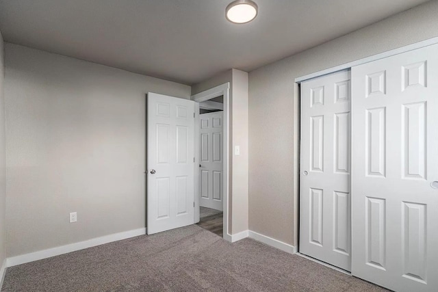 unfurnished bedroom with carpet flooring, baseboards, and a closet