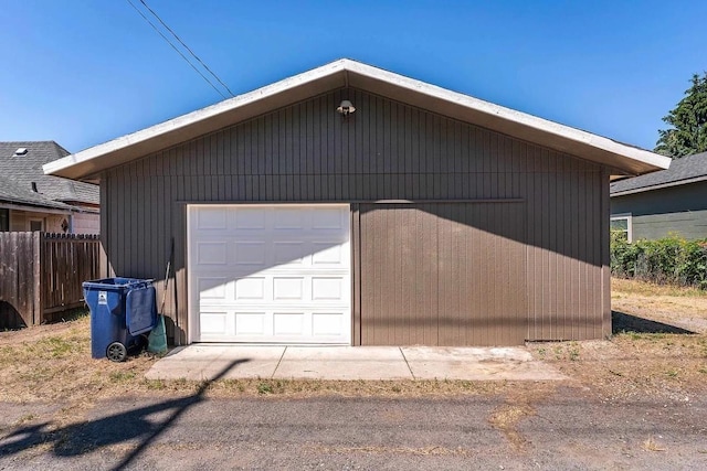 detached garage featuring fence