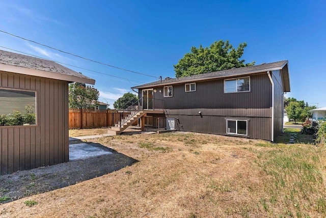 rear view of house featuring stairs and fence