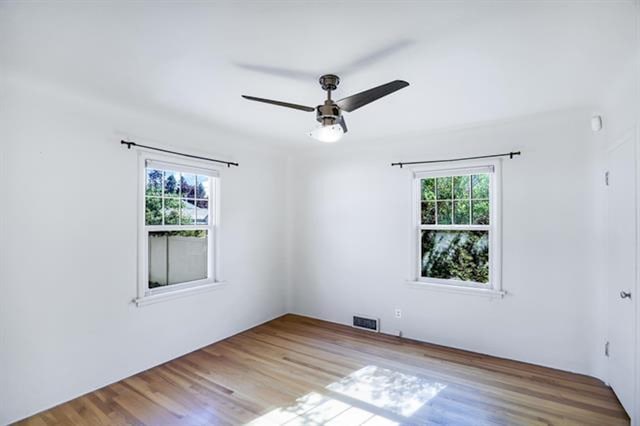 2424 W Fairview Ave, Spokane, WA 99205 - empty room with plenty of natural light, a ceiling fan, and wood finished floors