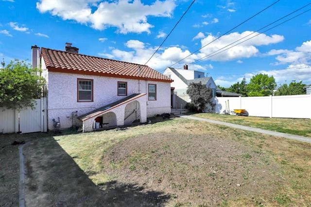 2424 W Fairview Ave, Spokane, WA 99205 - back of house with a chimney, a tile roof, and stucco siding