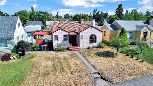 2424 W Fairview Ave, Spokane, WA 99205 - view of front facade featuring a tile roof, a chimney, a front lawn, and a residential view