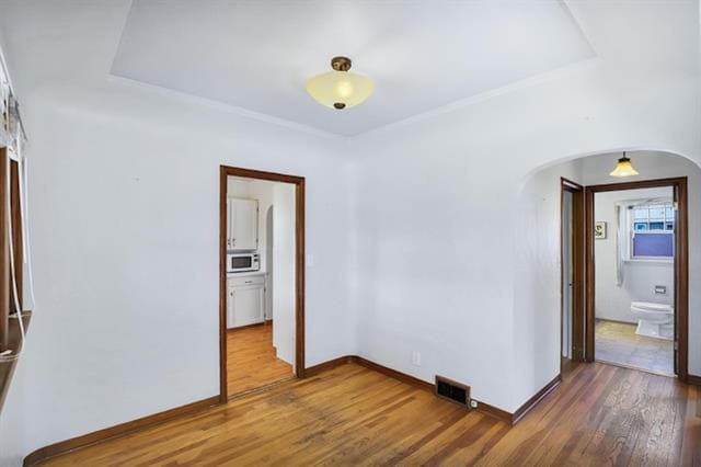2424 W Fairview Ave, Spokane, WA 99205 - spare room with arched walkways, wood finished floors, and baseboards
