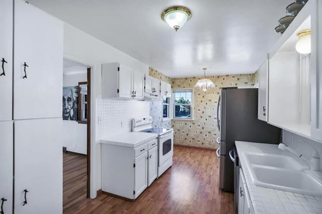 2424 W Fairview Ave, Spokane, WA 99205 - kitchen featuring electric stove, a sink, white cabinetry, and light countertops
