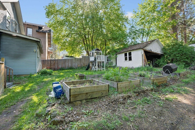 901 W 15th Ave, Spokane, WA 99203 - view of yard featuring a vegetable garden, a playground, and an outbuilding