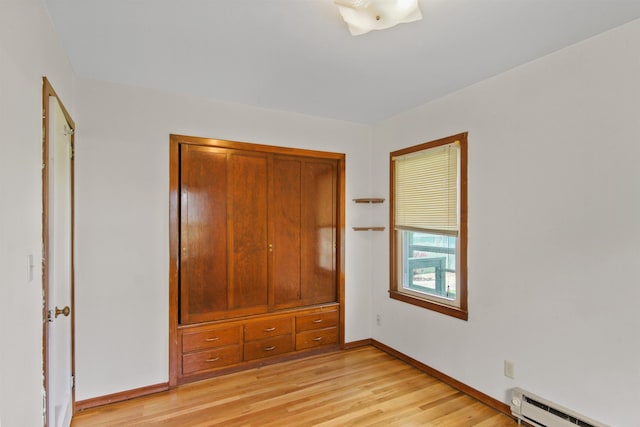 314 W Buckeye Ave, Spokane, WA 99205 - unfurnished bedroom featuring a baseboard radiator, light wood-type flooring, and baseboards