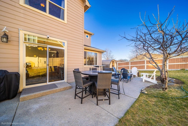 view of patio featuring fence, outdoor dining area, and grilling area