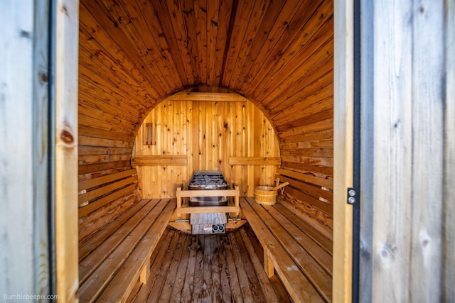 relaxing sauna featuring wooden ceiling and wood walls