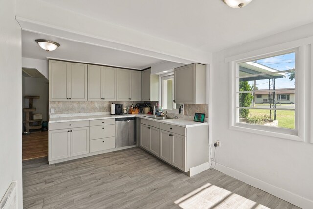 16813 E Valleyway Ave, Spokane Valley, WA 99037 - kitchen with stainless steel dishwasher, a sink, backsplash, light countertops, and gray cabinetry