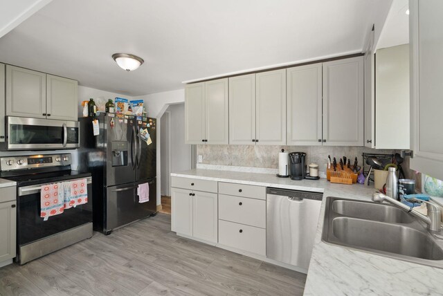 16813 E Valleyway Ave, Spokane Valley, WA 99037 - kitchen with appliances with stainless steel finishes, a sink, light countertops, light wood-style floors, and tasteful backsplash