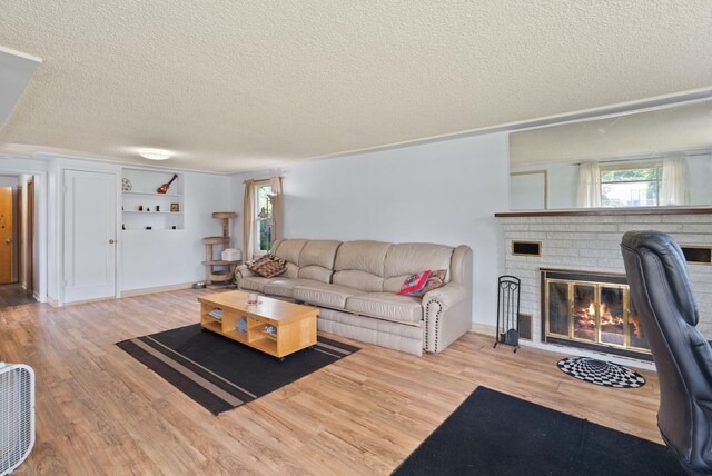 16813 E Valleyway Ave, Spokane Valley, WA 99037 - living room featuring a textured ceiling, wood finished floors, and a brick fireplace