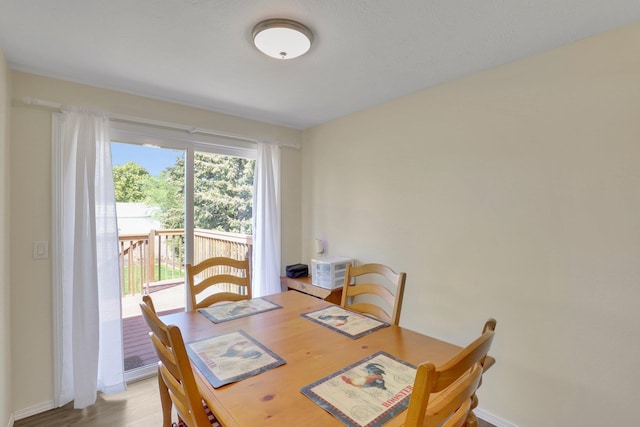 dining area with light wood-style flooring and baseboards