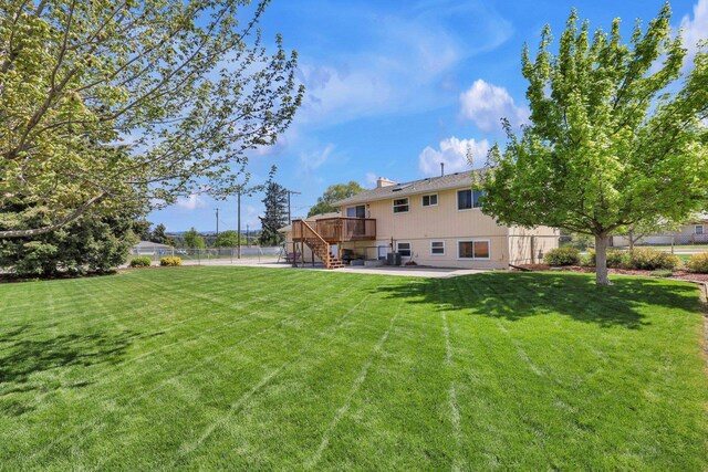 view of yard with stairway, a deck, and a patio