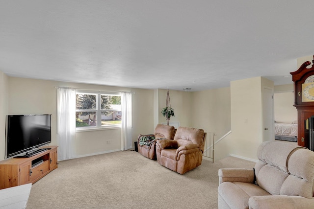carpeted living area featuring baseboards