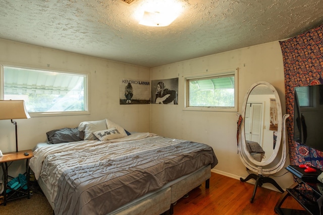 bedroom with wood finished floors and a textured ceiling