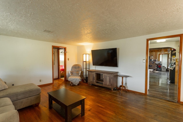 living room featuring a textured ceiling, wood finished floors, and baseboards