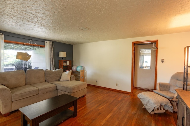 living area with a textured ceiling, plenty of natural light, wood finished floors, and baseboards