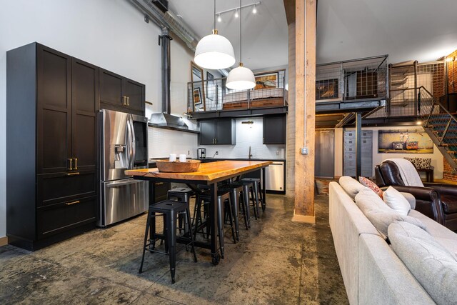 1016 W Railroad Ave Unit 202, Spokane, WA 99201 - kitchen featuring stainless steel fridge, a high ceiling, open floor plan, decorative light fixtures, and a sink