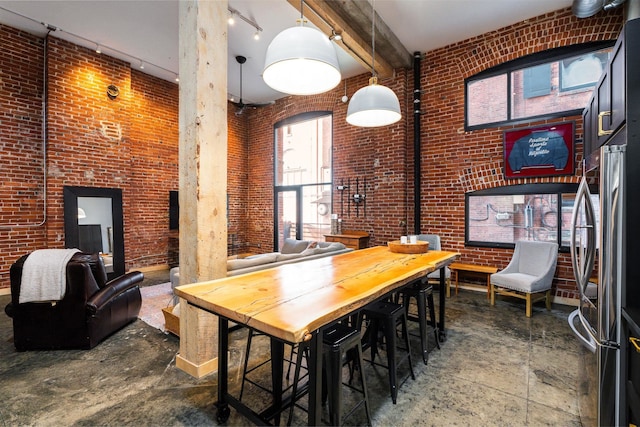 1016 W Railroad Ave Unit 202, Spokane, WA 99201 - dining area with brick wall, a high ceiling, track lighting, and concrete flooring