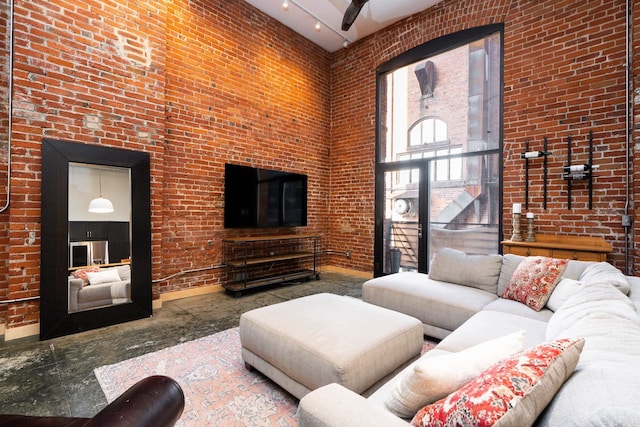 1016 W Railroad Ave Unit 202, Spokane, WA 99201 - living area featuring a towering ceiling, brick wall, and baseboards