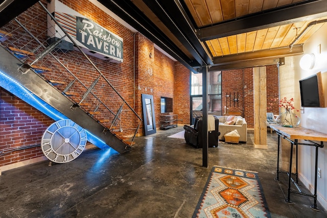 1016 W Railroad Ave Unit 202, Spokane, WA 99201 - living area with brick wall, concrete flooring, a high ceiling, beam ceiling, and wooden ceiling