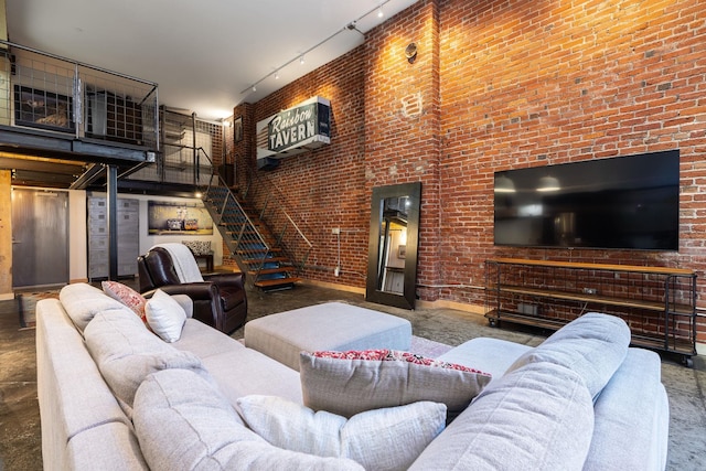 1016 W Railroad Ave Unit 202, Spokane, WA 99201 - living area featuring track lighting, a towering ceiling, stairway, baseboards, and brick wall