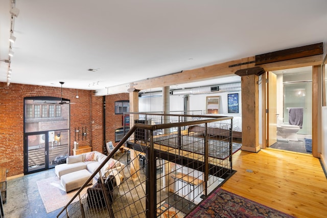1016 W Railroad Ave Unit 202, Spokane, WA 99201 - hall featuring rail lighting, brick wall, an upstairs landing, wood finished floors, and baseboards