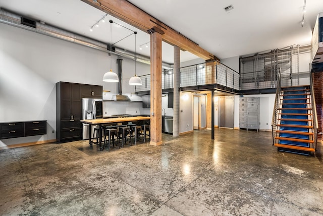 garage with stainless steel fridge with ice dispenser and baseboards