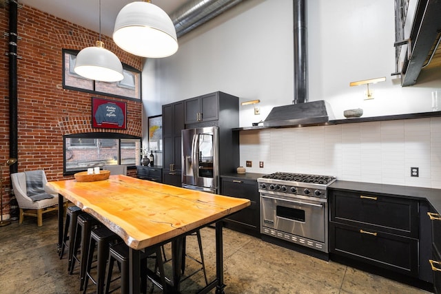 1016 W Railroad Ave Unit 202, Spokane, WA 99201 - kitchen featuring appliances with stainless steel finishes, a towering ceiling, dark countertops, dark cabinetry, and tasteful backsplash