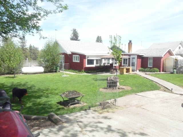 view of front of property featuring a chimney, a front yard, and an outdoor fire pit