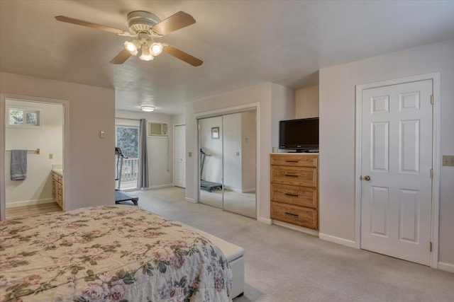 bedroom featuring light colored carpet, baseboards, connected bathroom, ceiling fan, and two closets