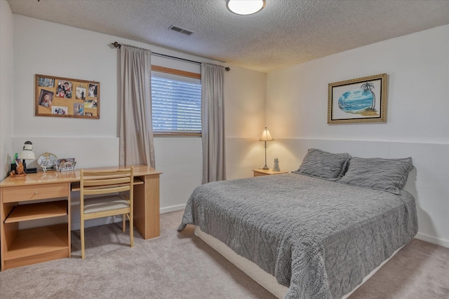 bedroom featuring carpet flooring, a textured ceiling, a desk, and baseboards
