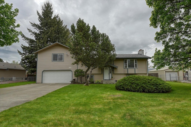 raised ranch with an attached garage, a chimney, and driveway