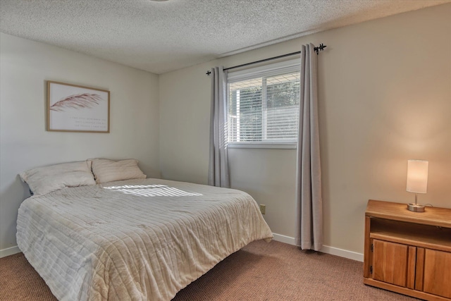 bedroom featuring light colored carpet, baseboards, and a textured ceiling