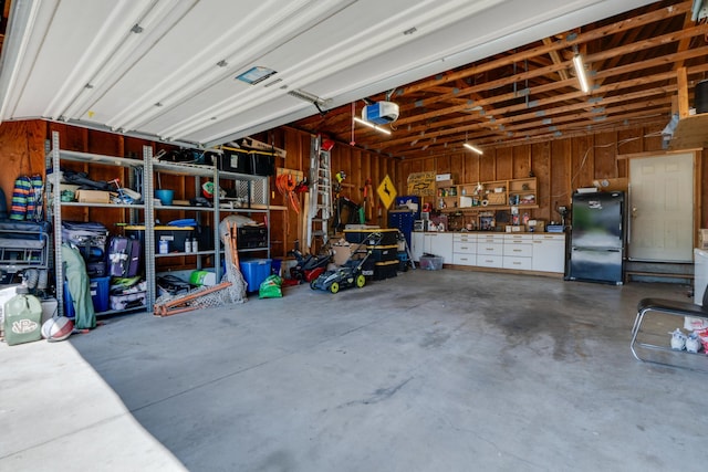 5212 N Bellevue Ct, Spokane Valley, WA 99216 - garage featuring freestanding refrigerator, a garage door opener, and a workshop area