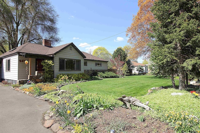 2423 N Bradley Rd, Spokane Valley, WA 99212 - view of home's exterior with a chimney, a lawn, and a shingled roof