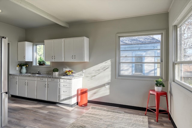 1121 W Knox Ave, Spokane, WA 99205 - kitchen with light wood-type flooring, healthy amount of natural light, white cabinets, and beamed ceiling
