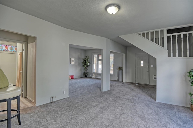 1121 W Knox Ave, Spokane, WA 99205 - unfurnished living room with carpet flooring, a textured ceiling, and baseboards