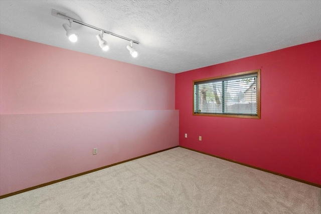 15121 N Meadowview Dr, Mead, WA 99021 - spare room featuring carpet flooring, track lighting, baseboards, and a textured ceiling