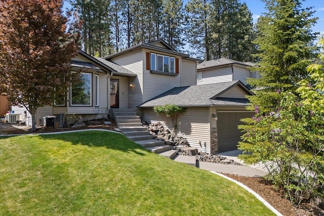 7110 S Moran View St, Spokane, WA 99224 - split level home featuring central air condition unit, a garage, a front yard, and a shingled roof